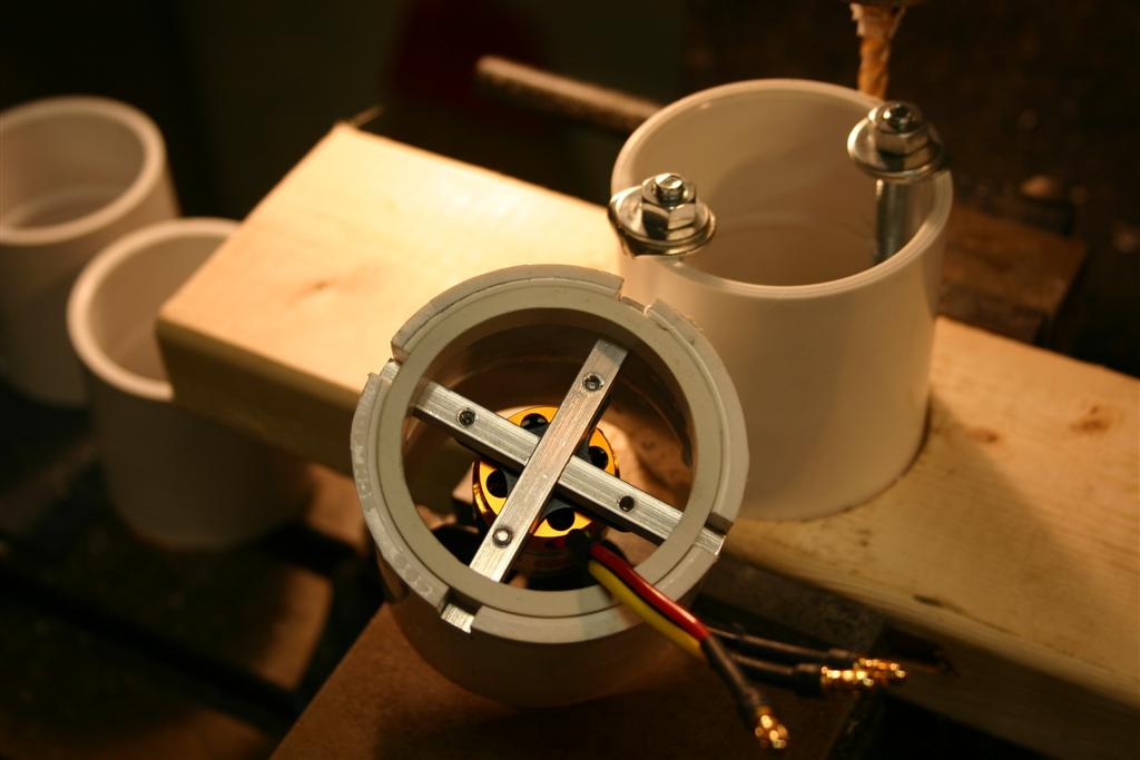 In this photo you can see the motor housing being milled. I made the jig in the photo to clamp the 2&quot; PVC pipe coupling while it was being milled. The slots are .25&quot; wide and were milled .600 deep. This allowed the .25&quot; motor supports to be pushed in and then a .35&quot; thick slice from a 2&quot; PVC pipe was installed to hold the motor supports in place.